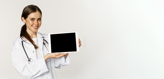 Gratis foto afbeelding van vrouwelijke arts vrouwelijke gezondheidswerker die online medische website digitale tablet scherm toont