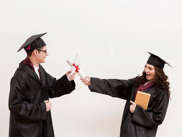 Afgestudeerde studenten vechten met diploma's