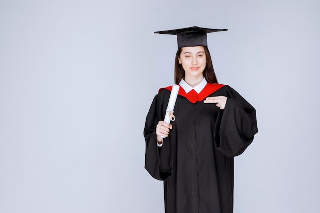 Afgestudeerde vrouwelijke student met diplomaviering succesvolle universiteitsgraduatie. Hoge kwaliteit foto