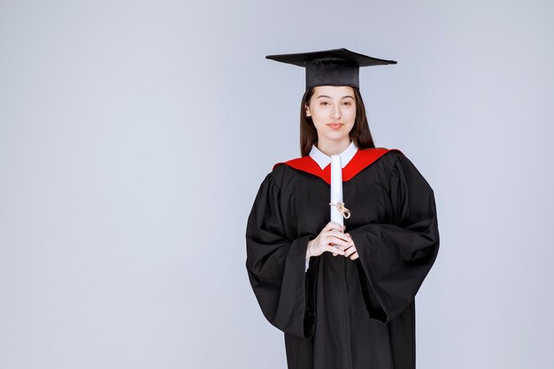 Afgestudeerde vrouwelijke student met diplomaviering succesvolle universiteitsgraduatie. Hoge kwaliteit foto