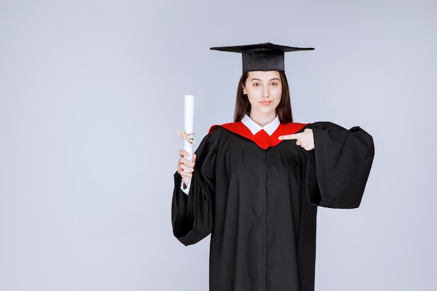 Afgestudeerde vrouwelijke student met diplomaviering succesvolle universiteitsgraduatie. Hoge kwaliteit foto