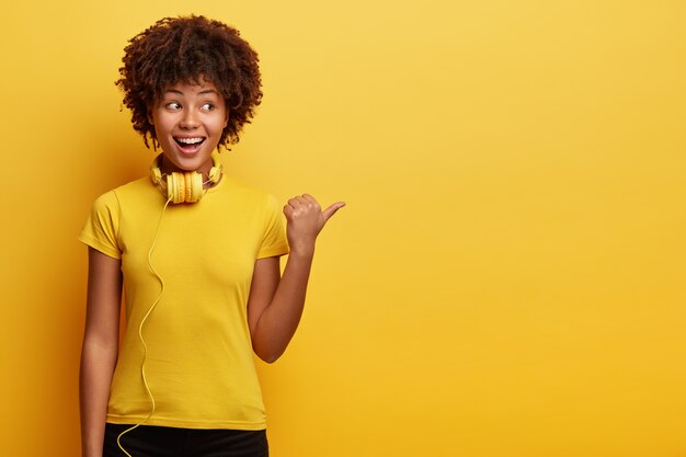 African American vrouw, gekleed in geel T-shirt en koptelefoon