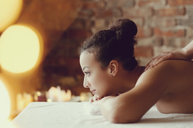 African American vrouw ontvangt een ontspannende massage in de spa
