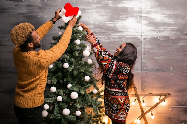 Afrikaans Amerikaans paar hangend speelgoed op een Kerstboom