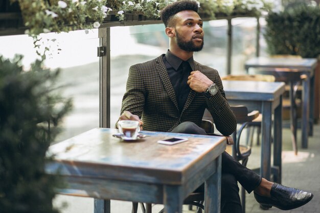 Afrikaanse Amerikaanse bedrijfsmens in een koffie het drinken koffie