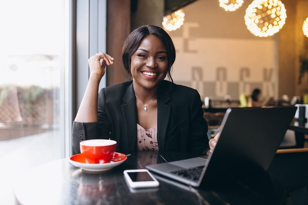 Afrikaanse Amerikaanse bedrijfsvrouw die in een koffie werkt