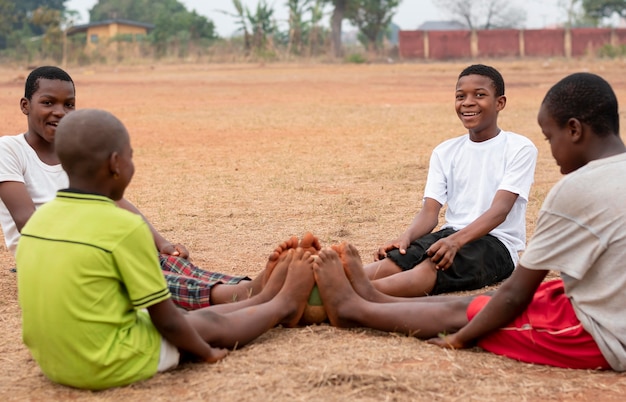 Afrikaanse kinderen met voetbal bal zitten