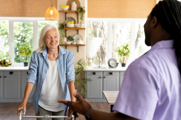 Afrikaanse maatschappelijk werker die voor een oudere vrouw zorgt