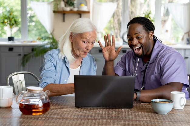 Afrikaanse maatschappelijk werker die voor een oudere vrouw zorgt