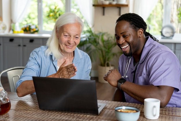 Afrikaanse maatschappelijk werker die voor een oudere vrouw zorgt