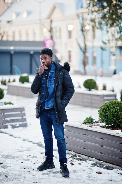 Afrikaanse man draagt jas bij koud winterweer buiten geposeerd