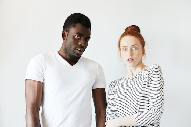 Afrikaanse man in wit T-shirt en roodharige blanke vrouw in gestreepte top