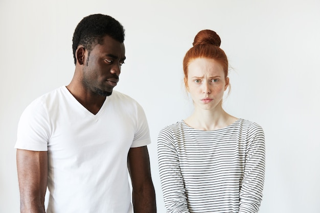 Afrikaanse man in wit T-shirt en roodharige blanke vrouw in gestreepte top