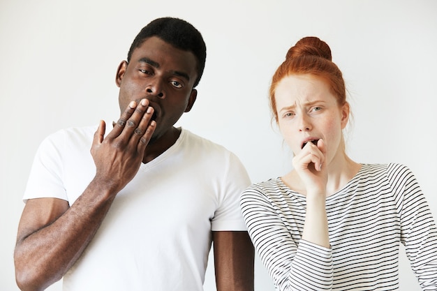 Afrikaanse man in wit t-shirt en roodharige blanke vrouw in gestreepte top