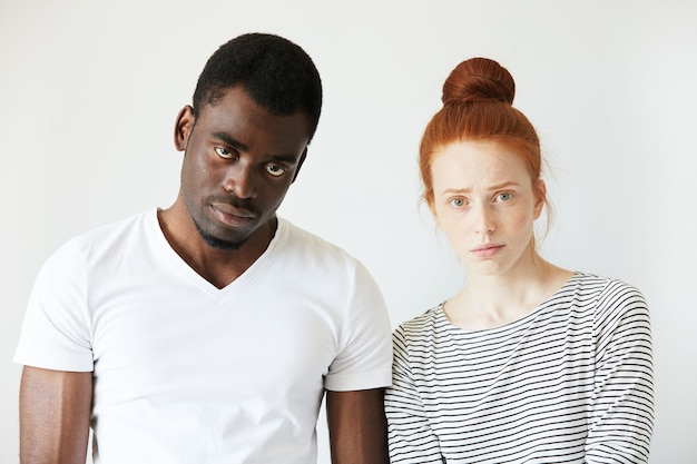 Afrikaanse man in wit T-shirt en roodharige blanke vrouw in gestreepte top