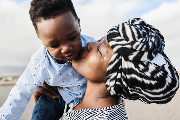 Afrikaanse moeder heeft een teder moment met zoontje buiten zachte focus op het gezicht van de moeder Premium Foto