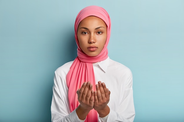 Afrikaanse moslimvrouw maakt traditioneel gebed tot god, houdt de handen in gebedgebaar