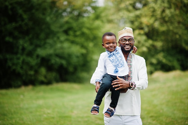 Afrikaanse vader met zoon in traditionele kleding bij park