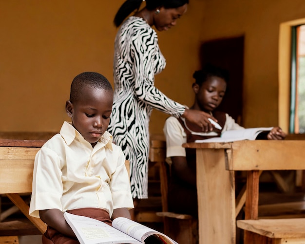 Afrikaanse vrouw lesgeven aan kinderen in de klas