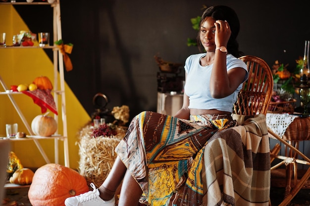 Afro-Amerikaans meisje zit op schommelstoel tegen herfststemming decoratie Fall in Africa