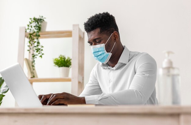 Gratis foto afro-amerikaanse man aan het werk laag uitzicht