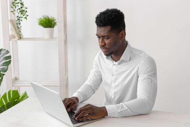 Afro-Amerikaanse man aan het werk op laptop