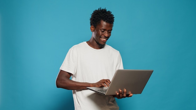 Afro-amerikaanse man die laptop gebruikt voor entertainment