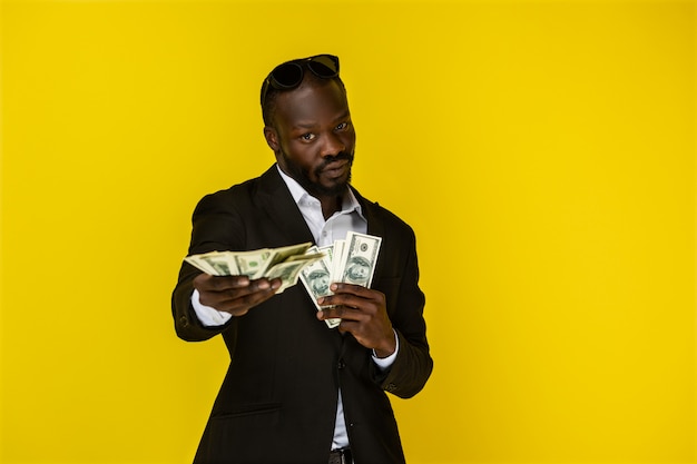 Afro-Amerikaanse man houdt veel geld in beide handen en kijkt voor zich uit