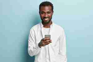 Gratis foto afro-amerikaanse man met een wit overhemd met telefoon
