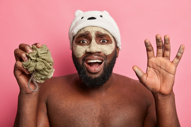 Afro-Amerikaanse man met kleimasker, spreekt geïsoleerde positieve emoties uit