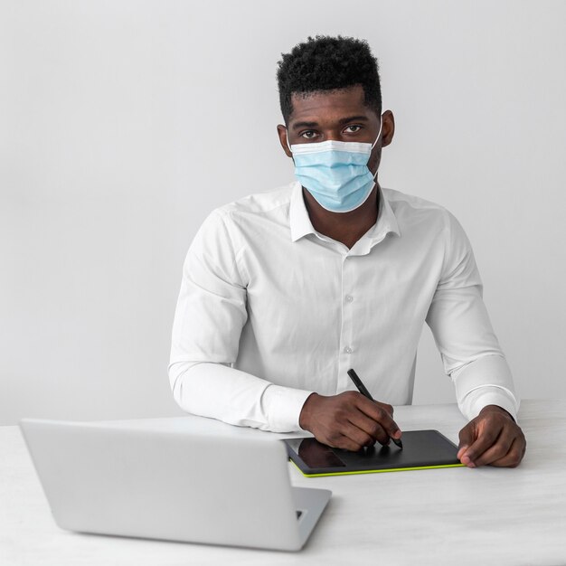 Afro-Amerikaanse man met medische masker op het werk