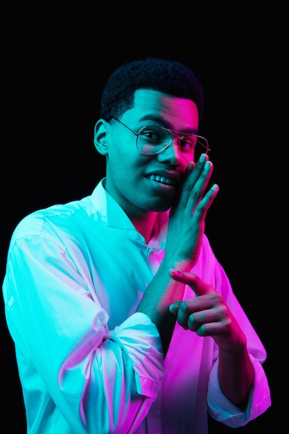 Afro-Amerikaanse man's portret geïsoleerd op zwarte studio achtergrond in veelkleurig neonlicht