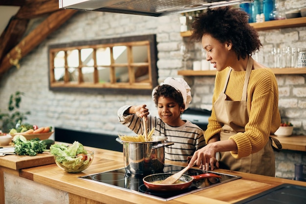 Afro-Amerikaanse moeder en zoon koken samen in de keuken