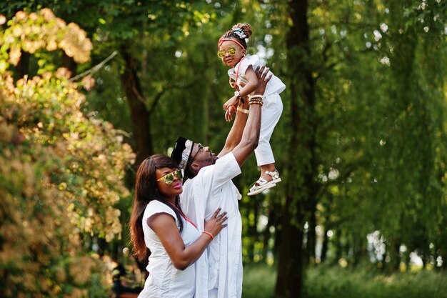 Afro-Amerikaanse rijke familie die plezier heeft bij zonsondergang Vader gooit dochter op zijn handen