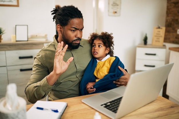 Afro-Amerikaanse vader en dochter hebben thuis videogesprek via laptop