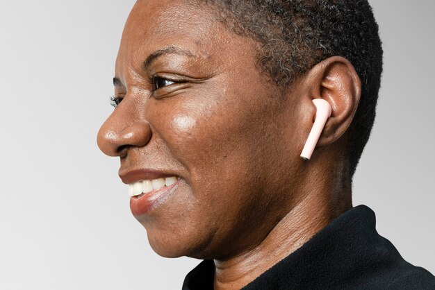 Afro-Amerikaanse vrouw die draadloze oordopjes draagt