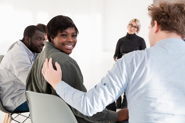 Afro-Amerikaanse vrouw die en fotograaf glimlacht bekijkt