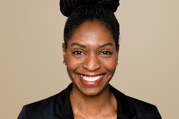 Afro-Amerikaanse vrouw die lacht op beige achtergrond