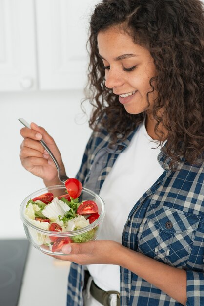 Afro-Amerikaanse vrouw die veganistsalade eet