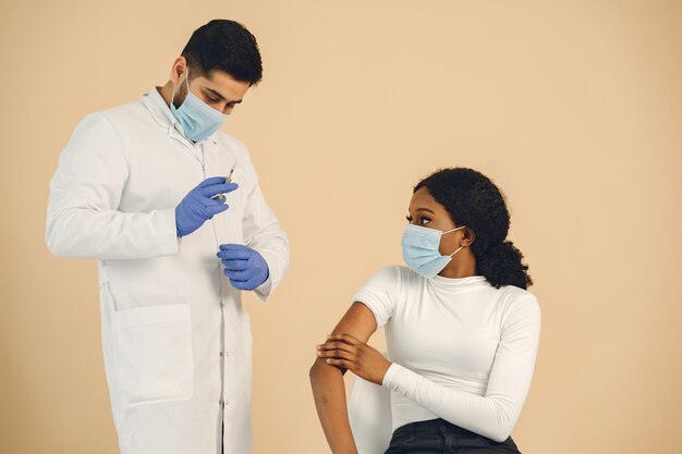 Afro-Amerikaanse vrouw die wordt ingeënt, geïsoleerd. Coronavirus-concept.