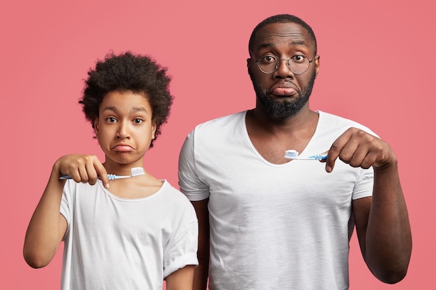 Afro-Amerikaanse zoon en vader met tandenborstels