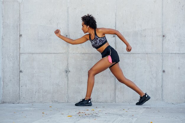 Afro atletische vrouw uitgevoerd en oefening buitenshuis. Sport en een gezonde levensstijl concept.