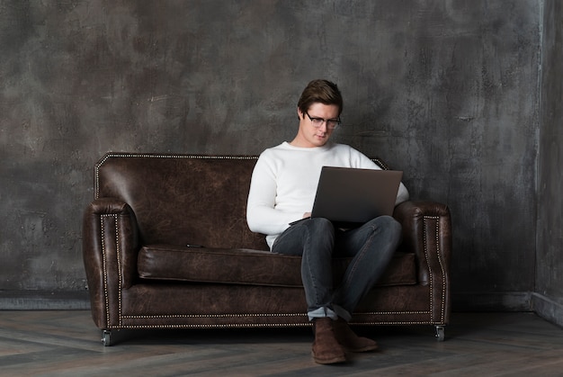 Afstandsschot moderne mens die aan laptop met exemplaarruimte werkt