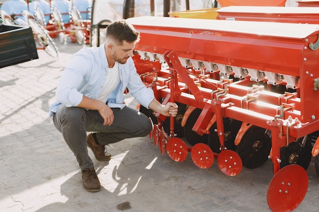 Gratis foto agronoom die een nieuwe planter kiest. man op het buitenterrein van de winkel. landbouwmachines.