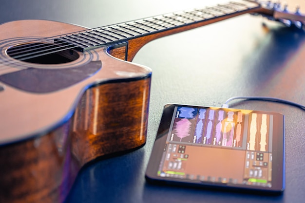 Gratis foto akoestische gitaar en tablet op de tafel muziek opname concept