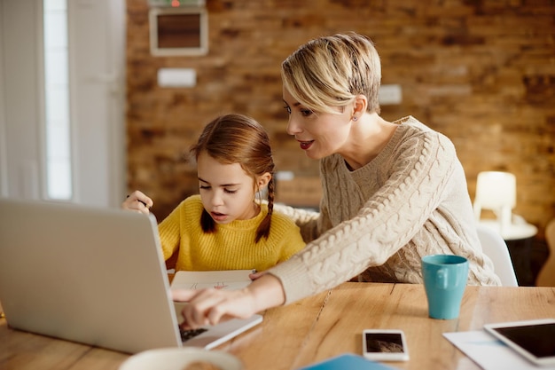 Gratis foto alleenstaande moeder en dochter die laptop gebruiken tijdens thuisonderwijs