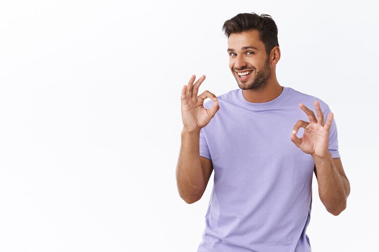 Gratis Foto alles goed, maak je geen zorgen. guy heeft alles onder controle, aantrekkelijke man met assertieve glimlach, moedig vriend aan dat hij uitstekend werk heeft geleverd, prijs mooie resultaten, toont oké, ok gebaar ter goedkeuring