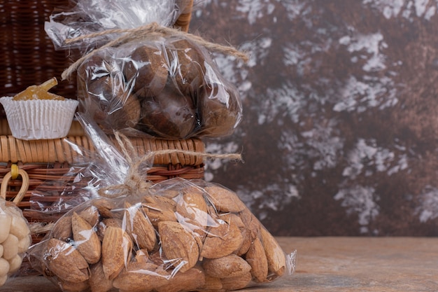 Amandelen en kastanjes verpakt in plastic zak op houten tafel.