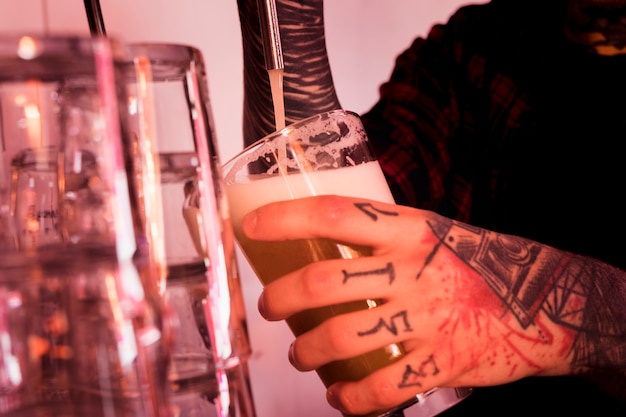 Gratis foto ambachtelijke bier concept met getatoeëerde man