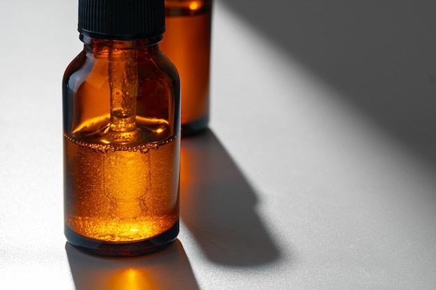 Amberglazen flessen voor cosmetica, natuurlijke geneeskunde of etherische oliën op grijze achtergrond